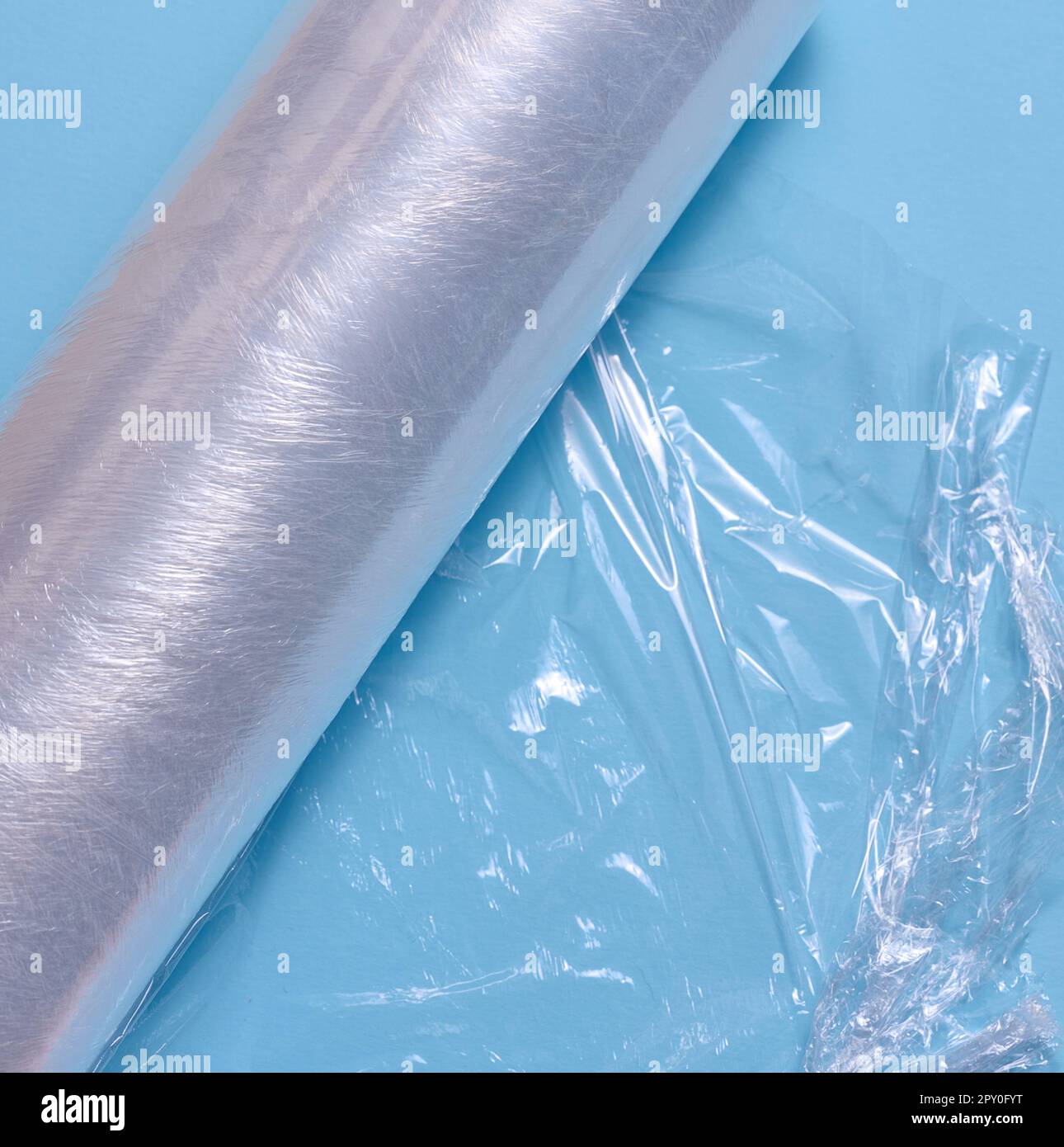 Crumpled transparent polyethylene on a blue background, top view Stock Photo
