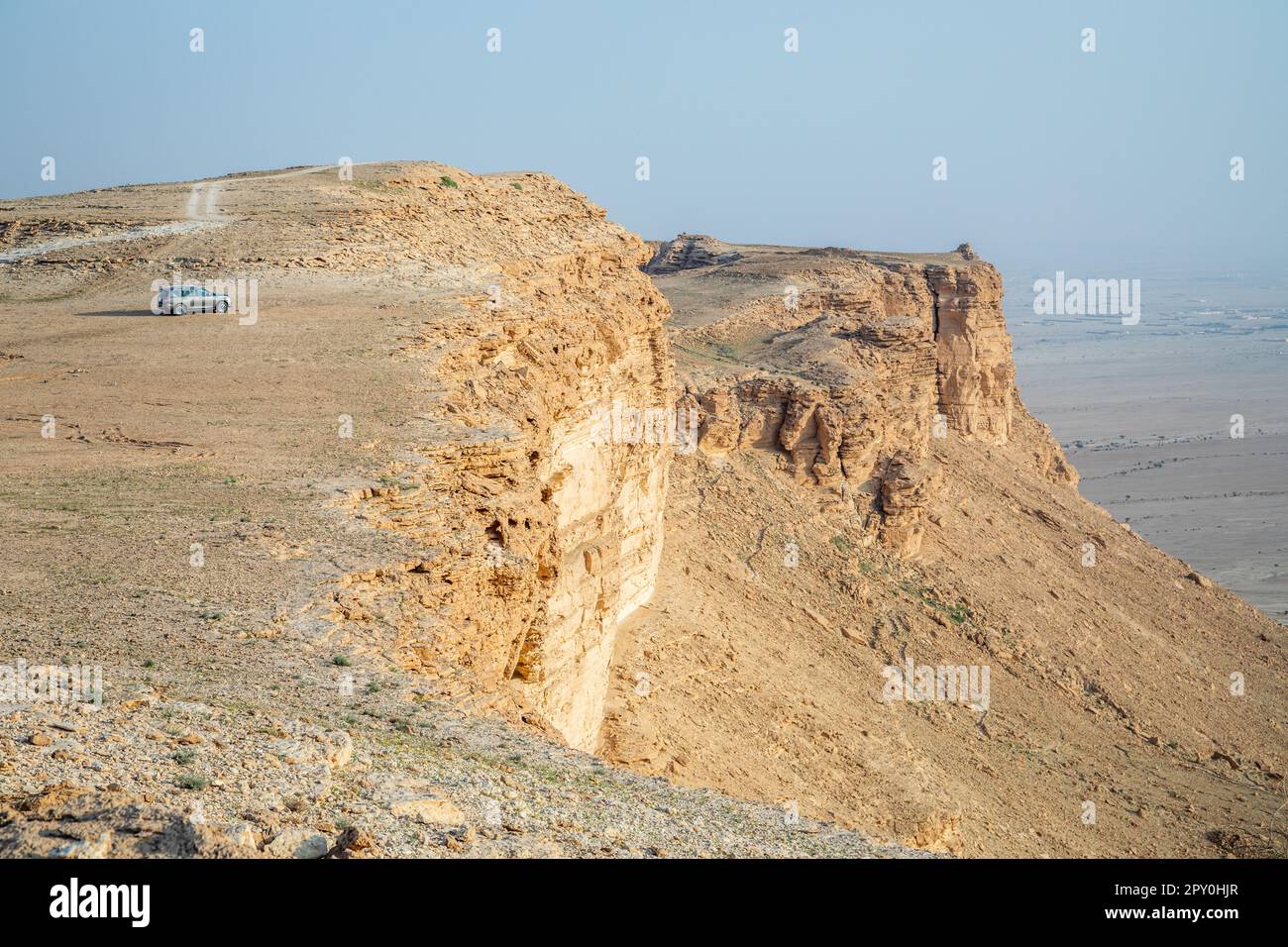 Car on the edge of the Jabal Tuwaiq Mountains, with desert below landscape, Riyadh, Saudi Arabia Stock Photo