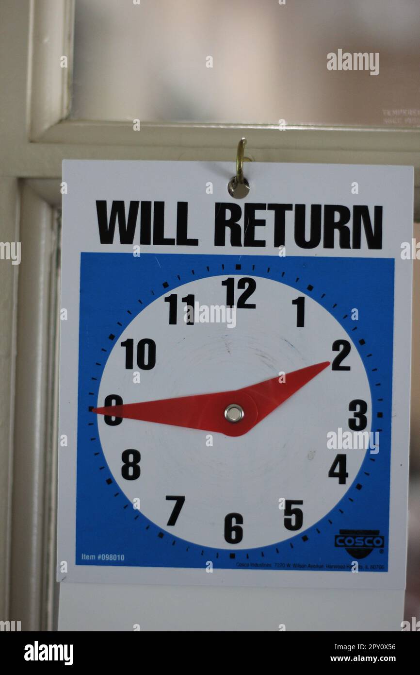 'WILL RETURN' clock on the door of an office letting patrons know when they will return. Sometimes they don't! Stock Photo