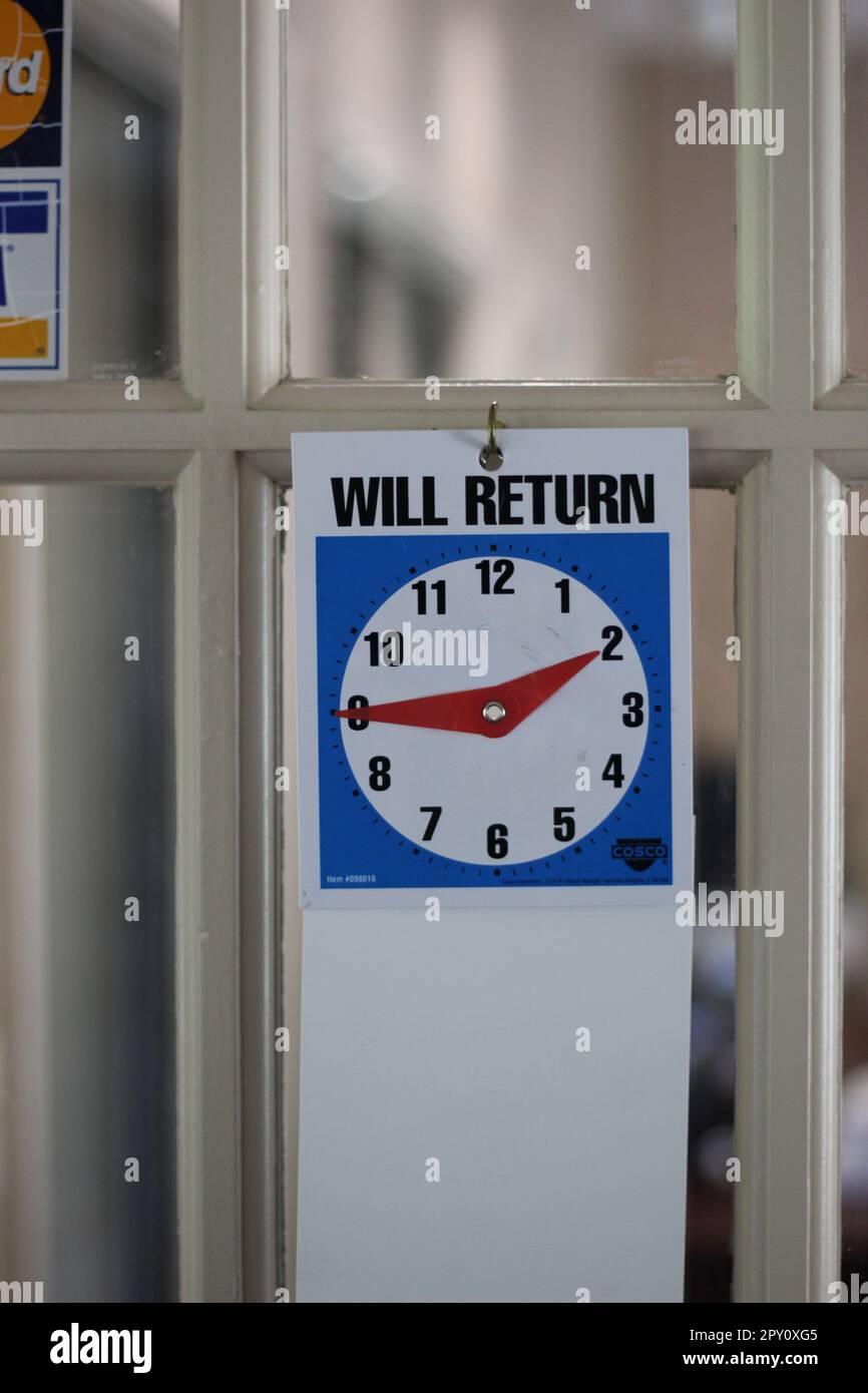 "WILL RETURN" clock on the door of an office letting patrons know when