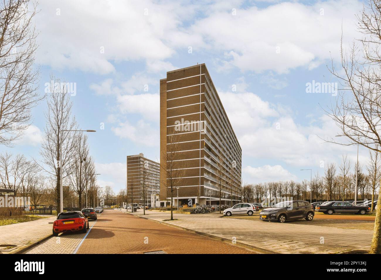 a city street with cars parked on the side and tall buildings in the ...