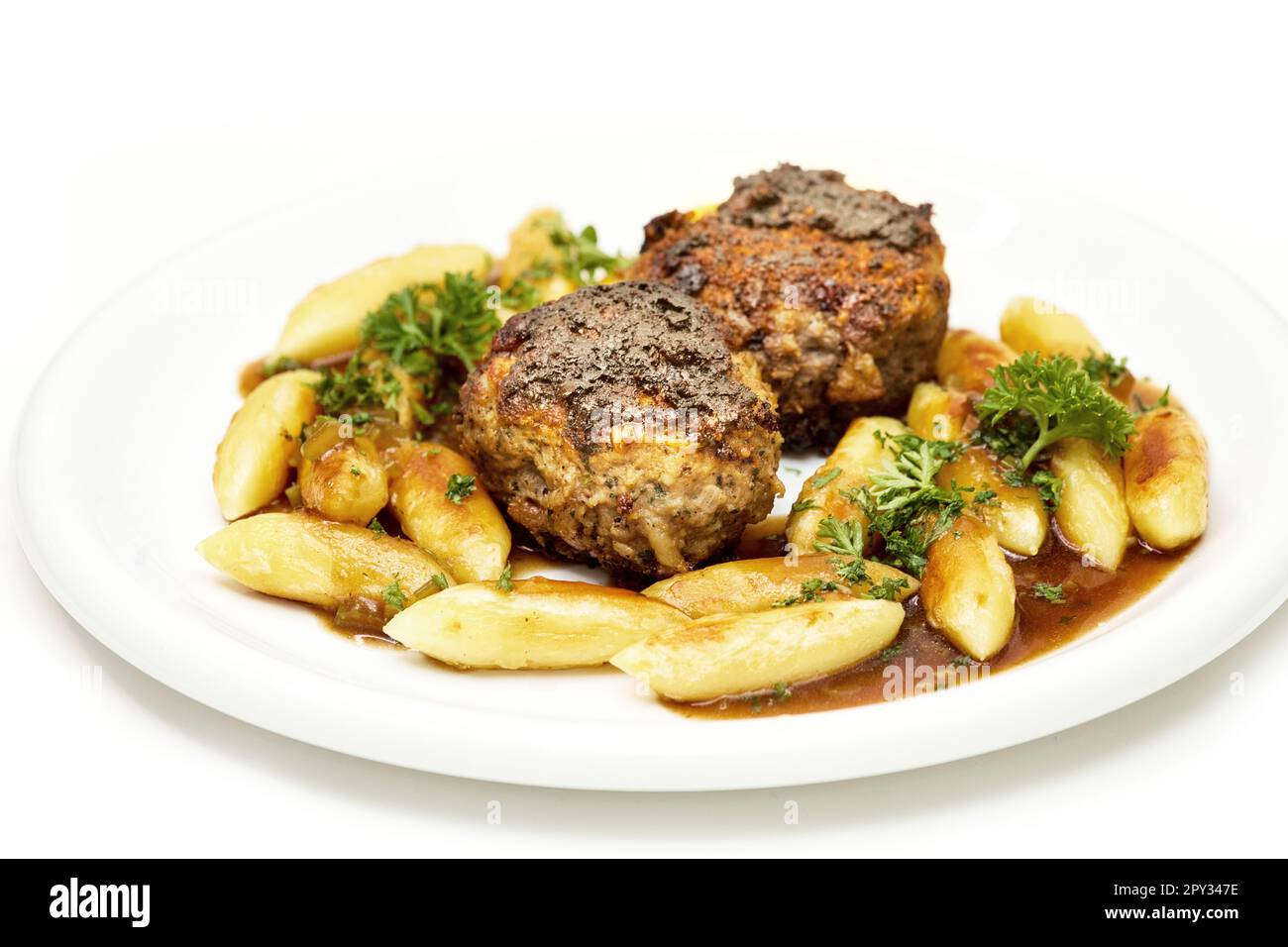 Delicious home cooking: Meatballs with Potato noodles and parsley in hearty gravy Stock Photo