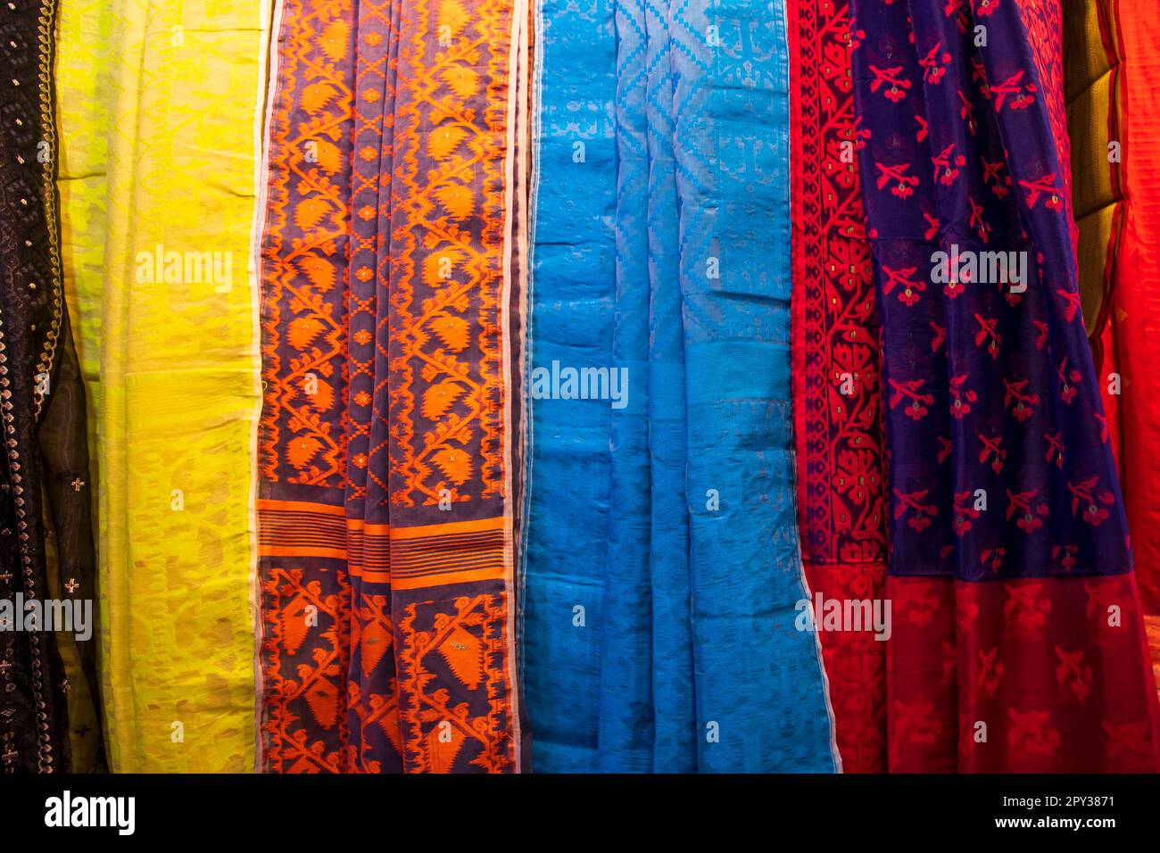 Bangladeshi Women's Traditional Colorful Jamdani saree hanging in the retail Showrooms. Colorful Jamdani Saree Texture Background Stock Photo