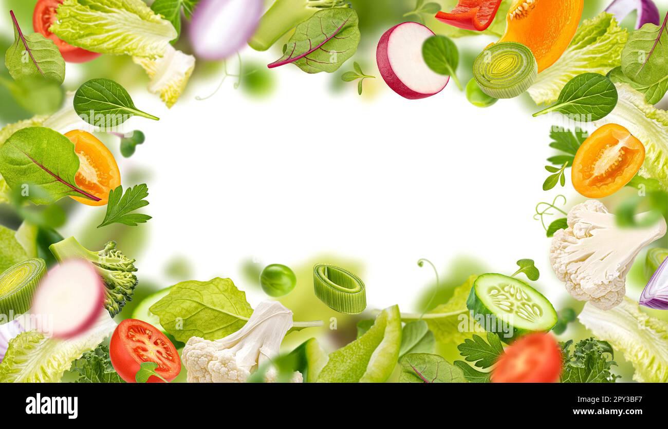 Healthy food ingredients frame, superfood, falling salad leaves and vegetable slices Stock Photo