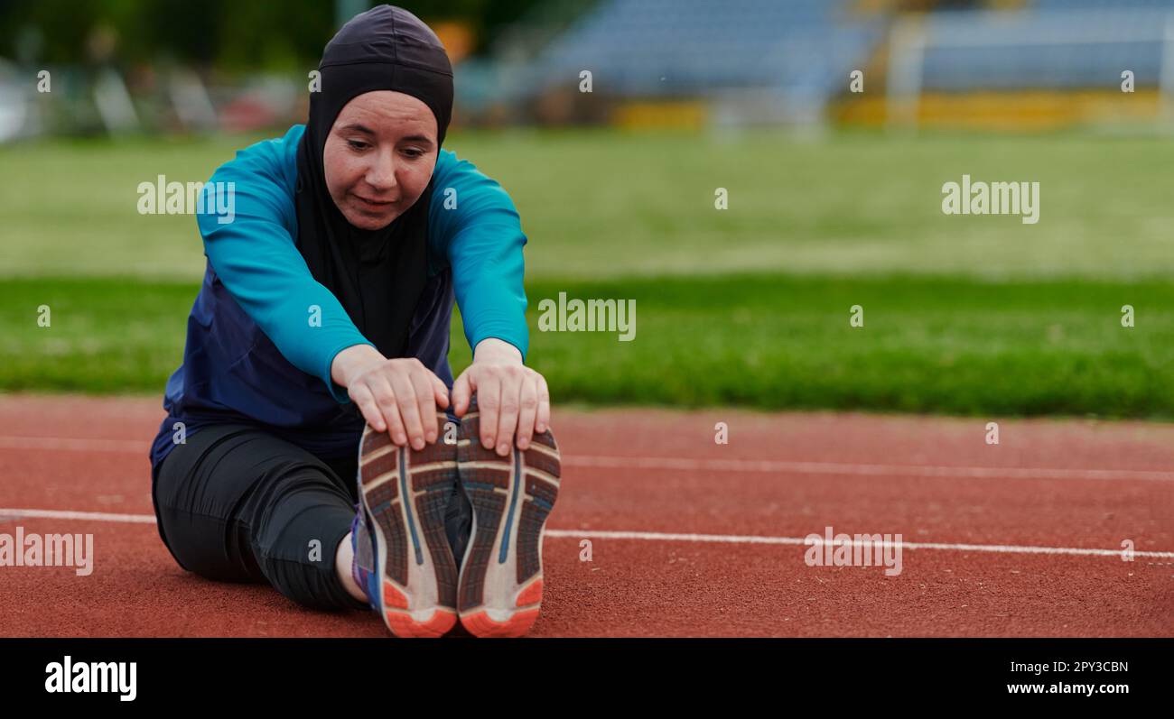A Muslim woman in a burqa, an Islamic sports outfit, is doing body