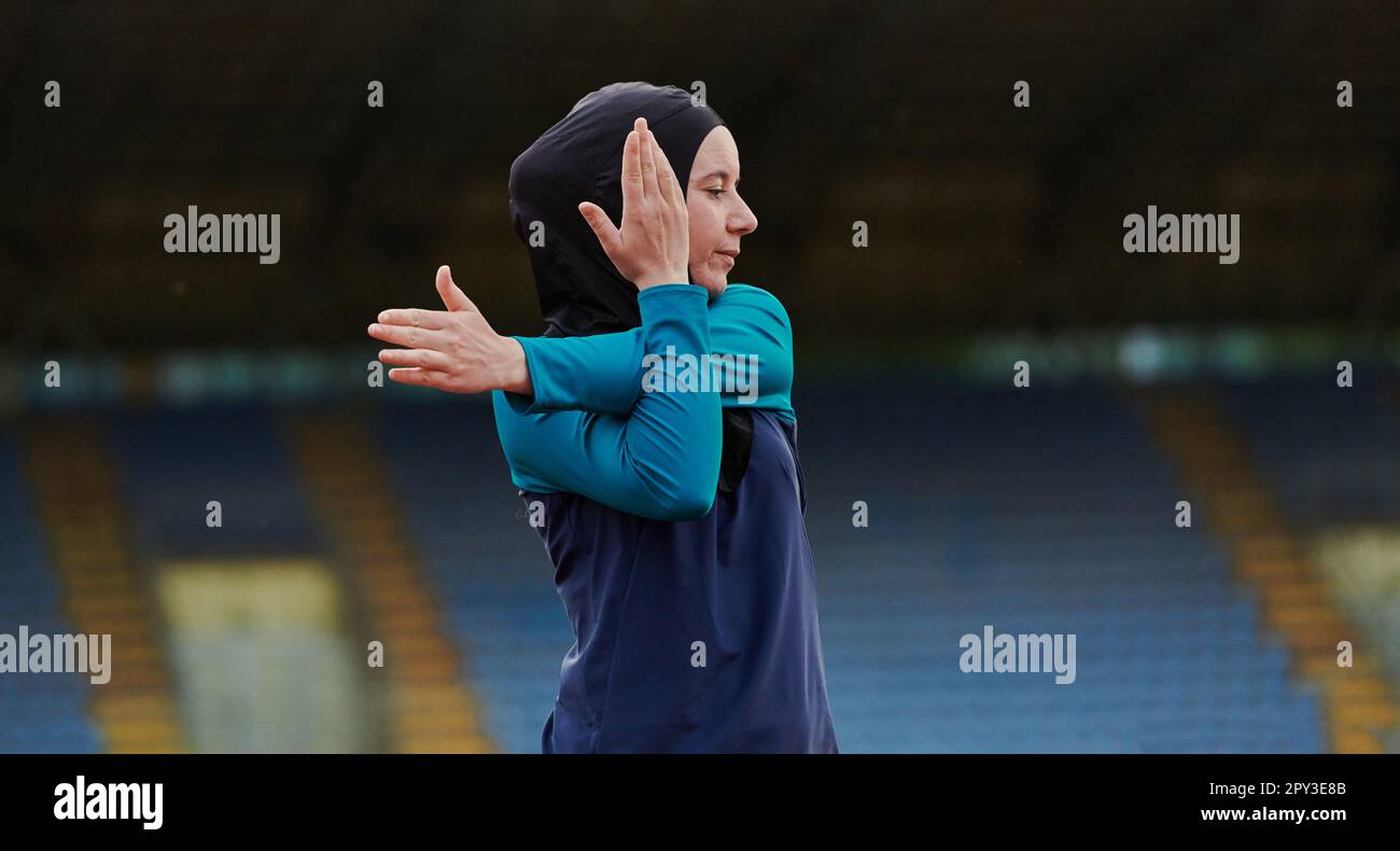 A Muslim woman in a burqa, an Islamic sports outfit, is doing body