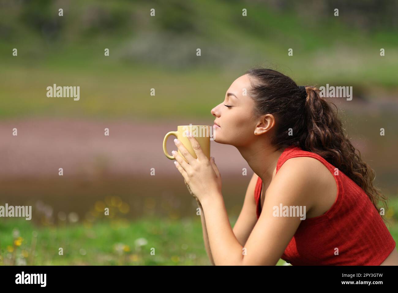 Profile of a woman in the mountain smelling coffee Stock Photo - Alamy