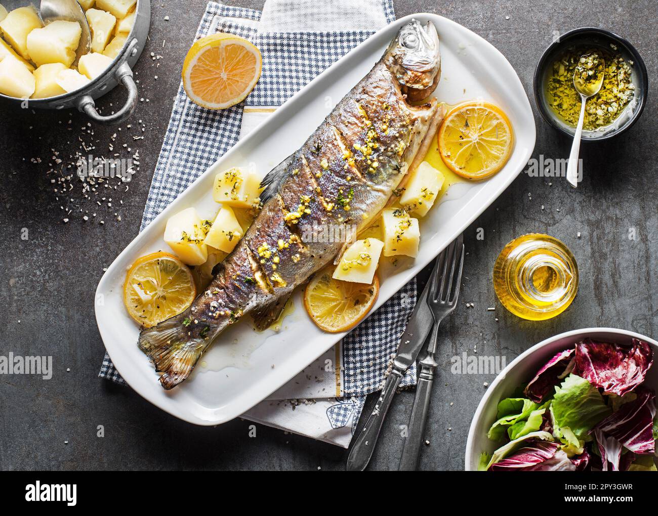 Roasted traditional river trout with salad, potatoes and (garlic