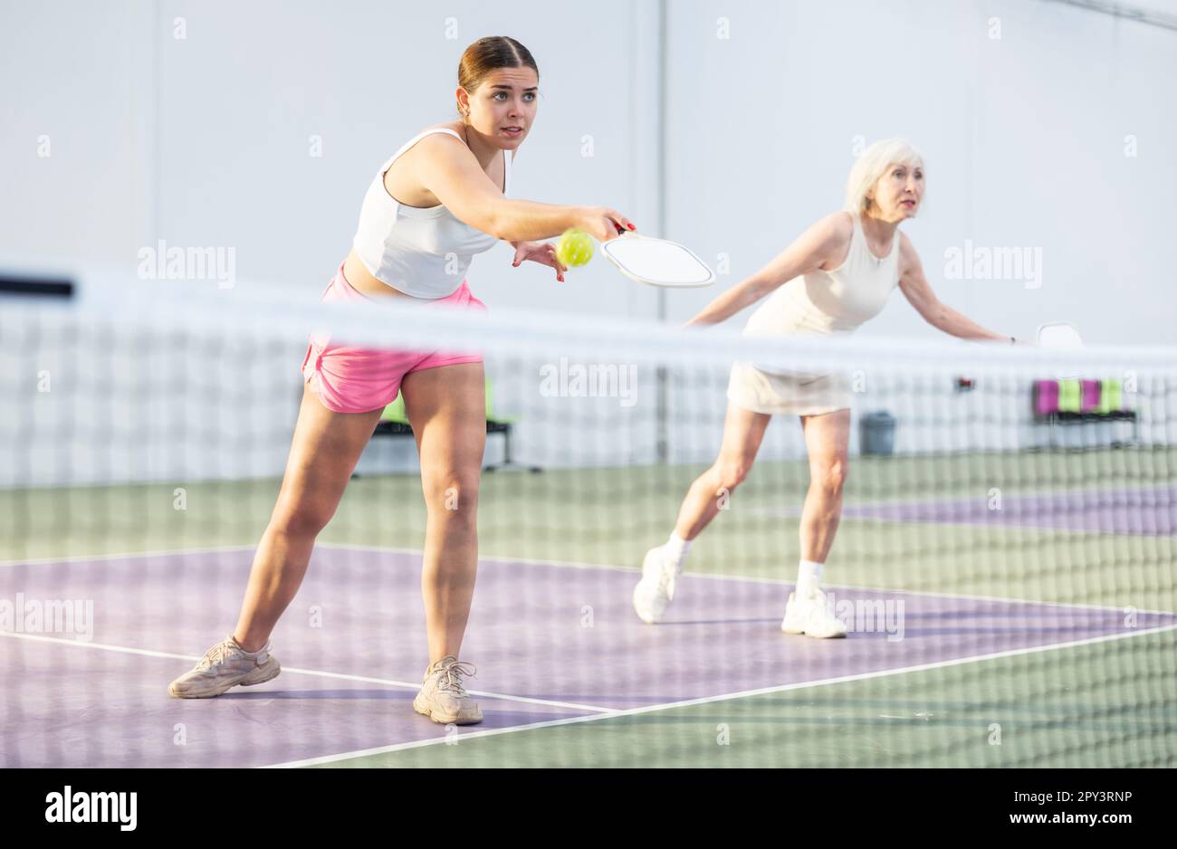 Young girl playing doubles pickleball match with aged female partner Stock Photo Alamy