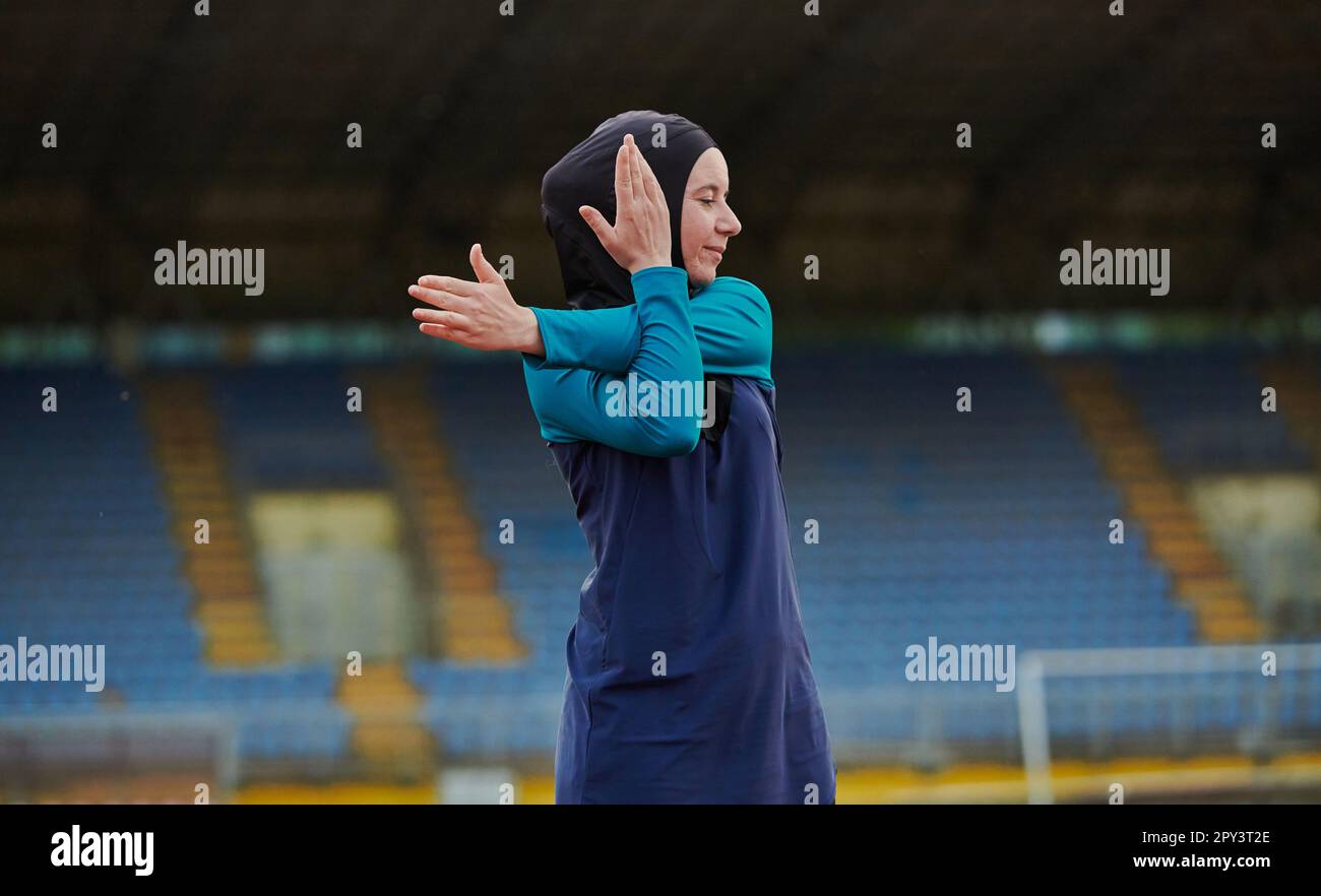 A Muslim woman in a burqa, an Islamic sports outfit, is doing body