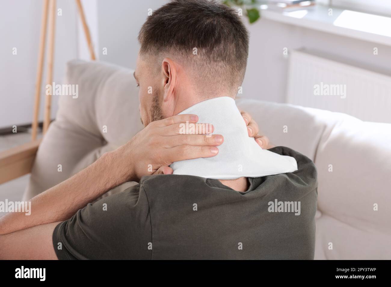 Man using heating pad at home, back view Stock Photo Alamy