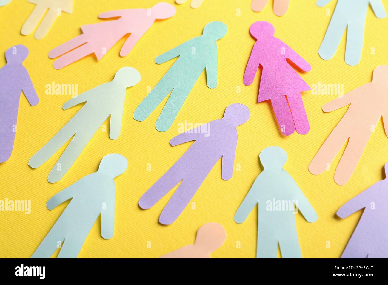 Many different paper human figures on yellow background. Diversity and inclusion concept Stock Photo