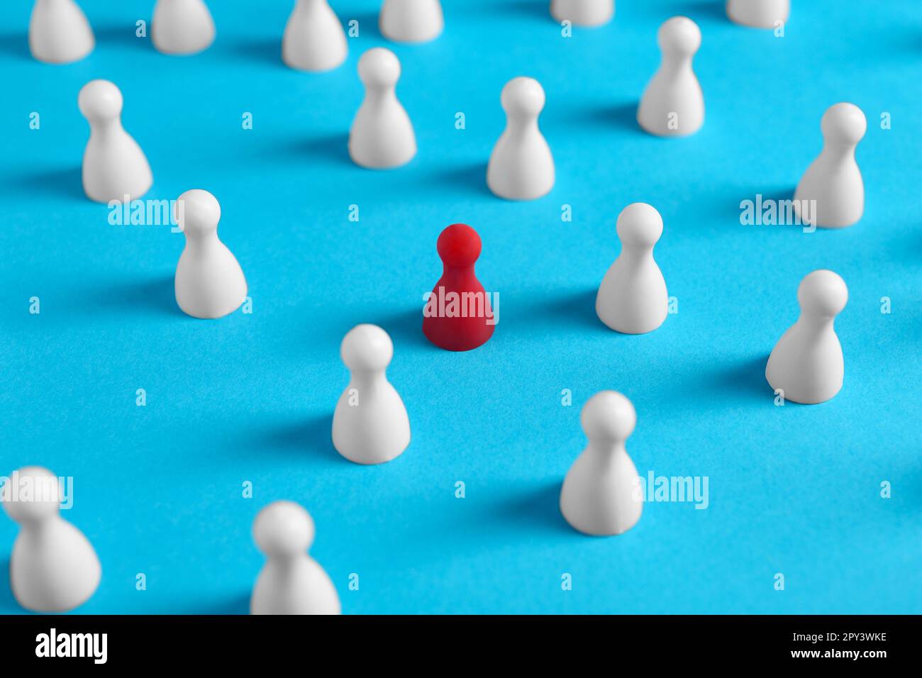 One red pawn among others on light blue background. Social inclusion ...