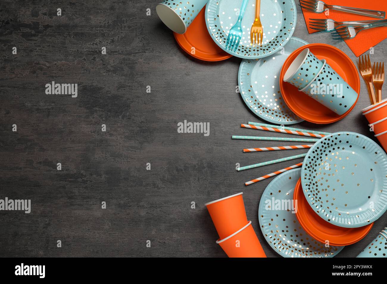 Flat lay composition with disposable tableware on dark grey background ...