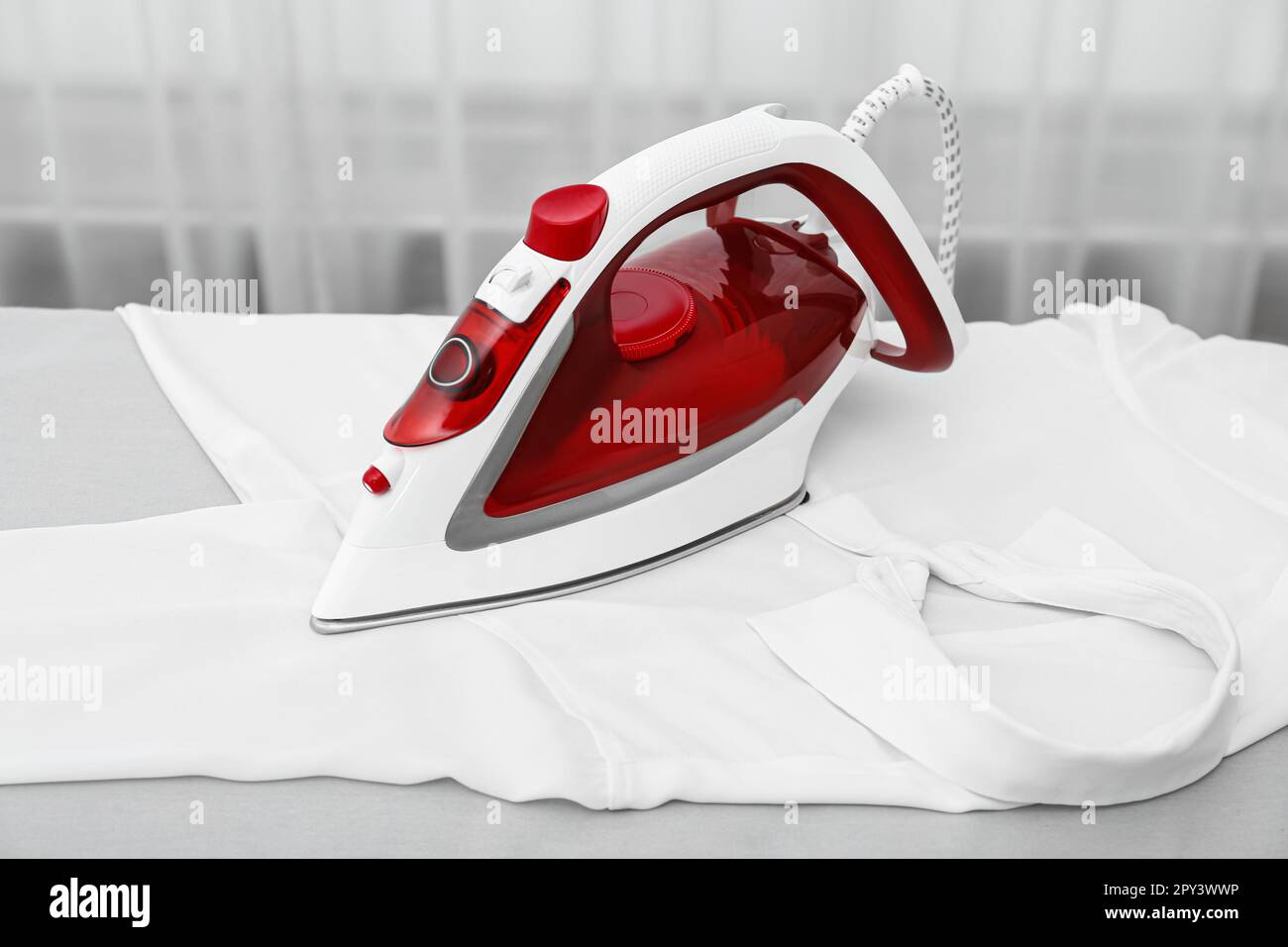 Modern iron and white clean shirt on board indoors Stock Photo - Alamy
