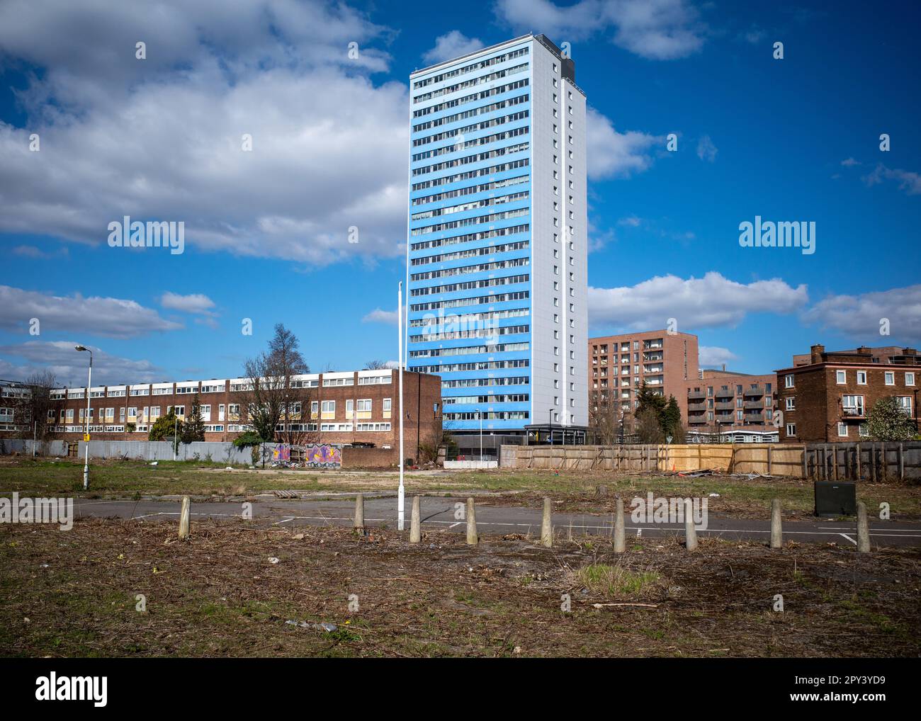 Ferrier Point tower block in Newham, East London. Blue cladded high rise residential viewed from wasteland. Old Housing Estate, regeneration. Stock Photo