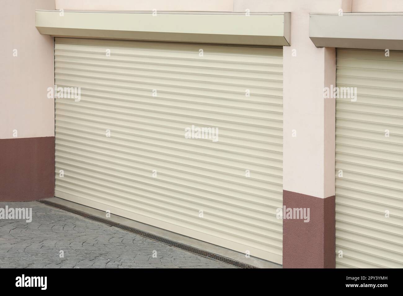Building with white roller shutter garage doors Stock Photo Alamy