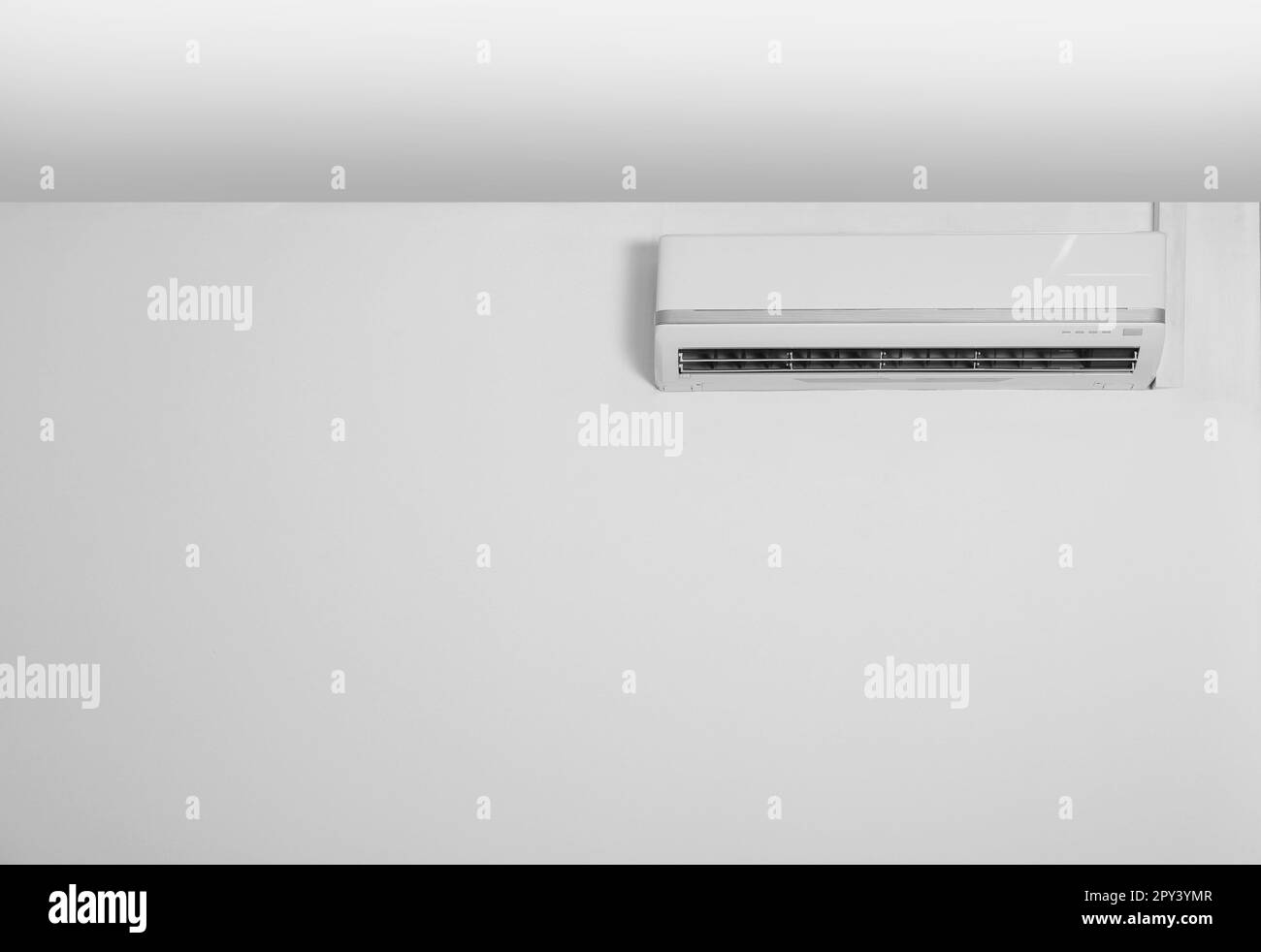 Modern air conditioner on white wall indoors Stock Photo - Alamy