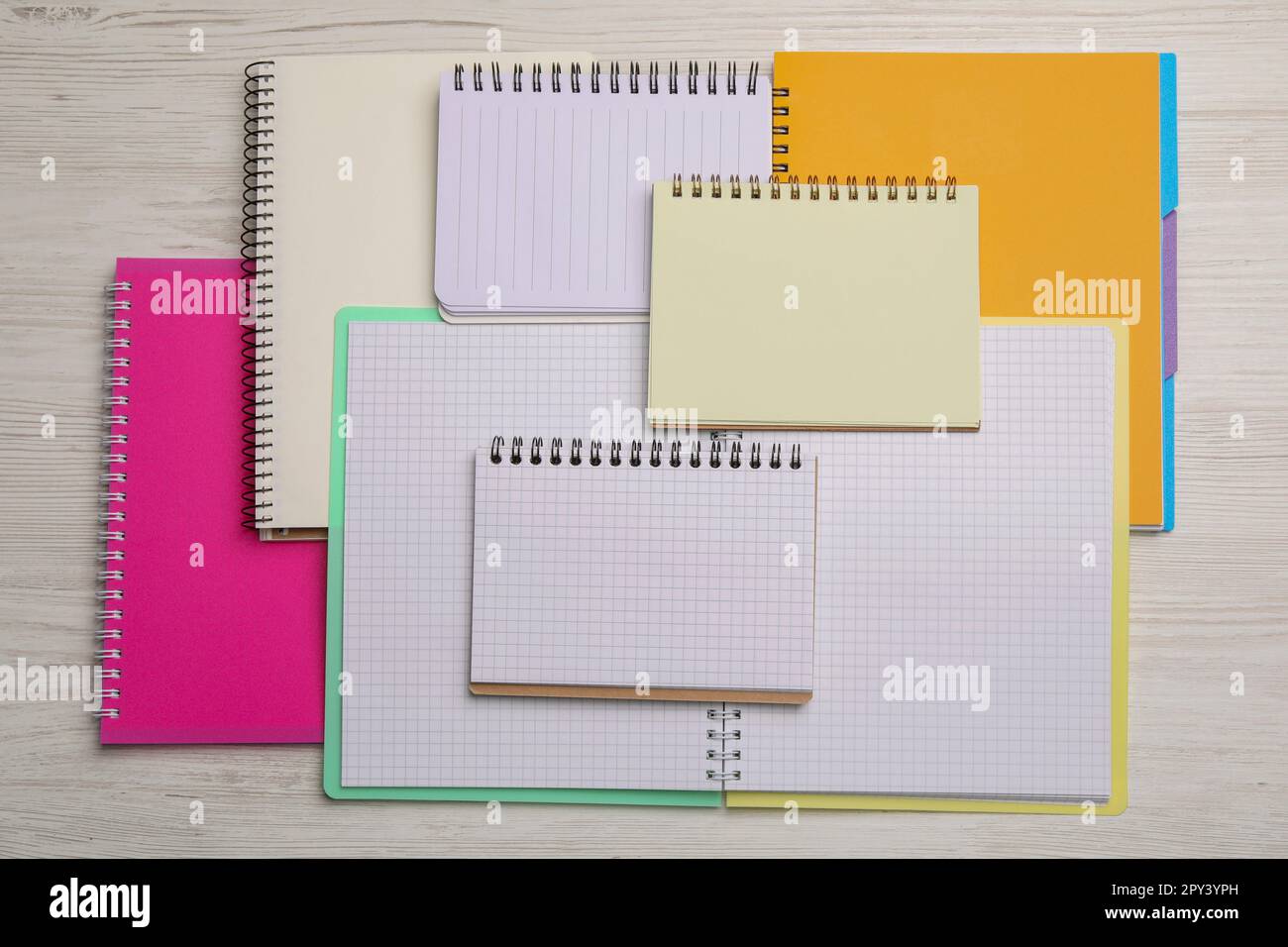 Many different notebooks on white wooden table, flat lay Stock Photo