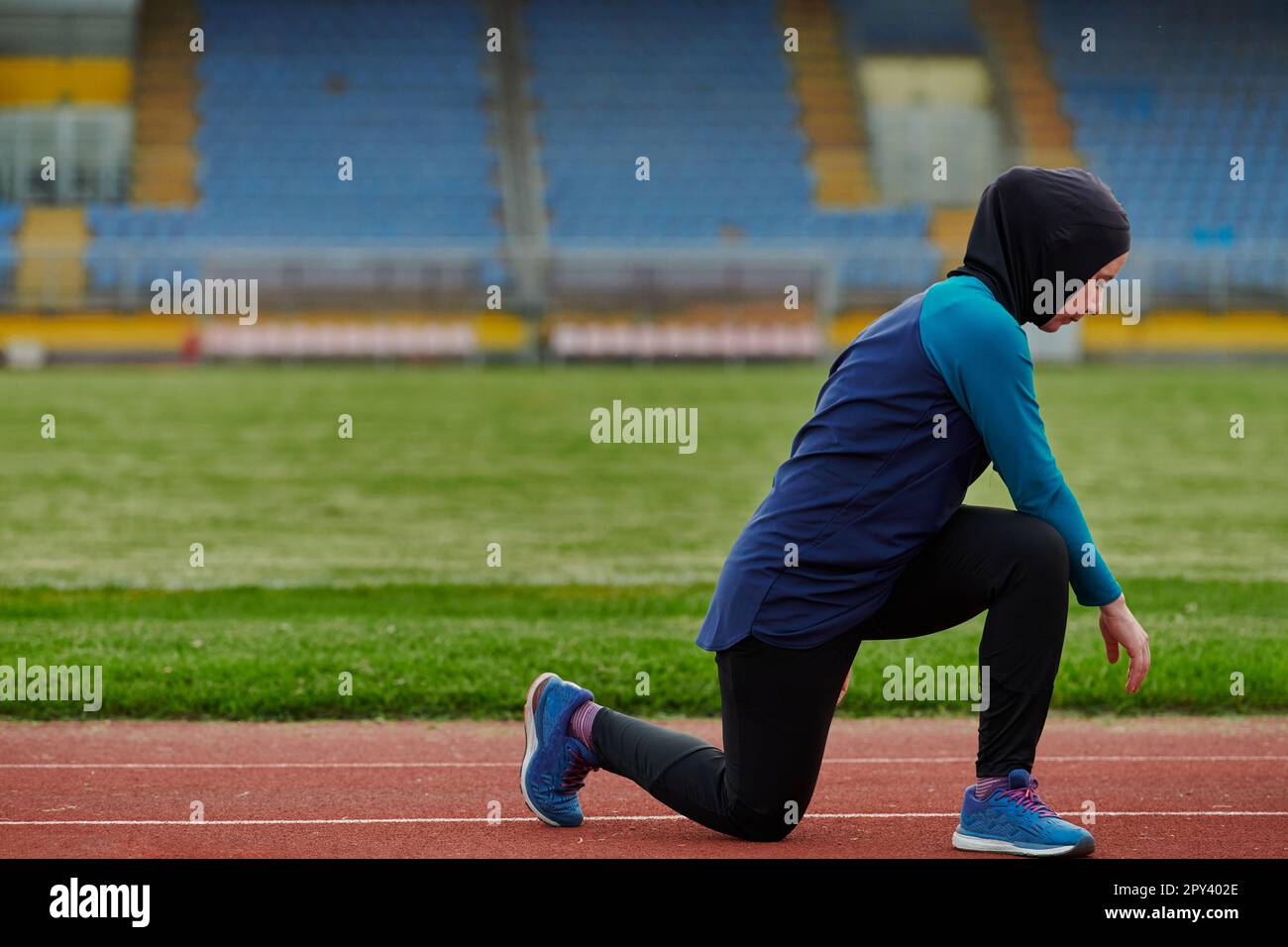 A Muslim woman in a burqa, an Islamic sports outfit, is doing body