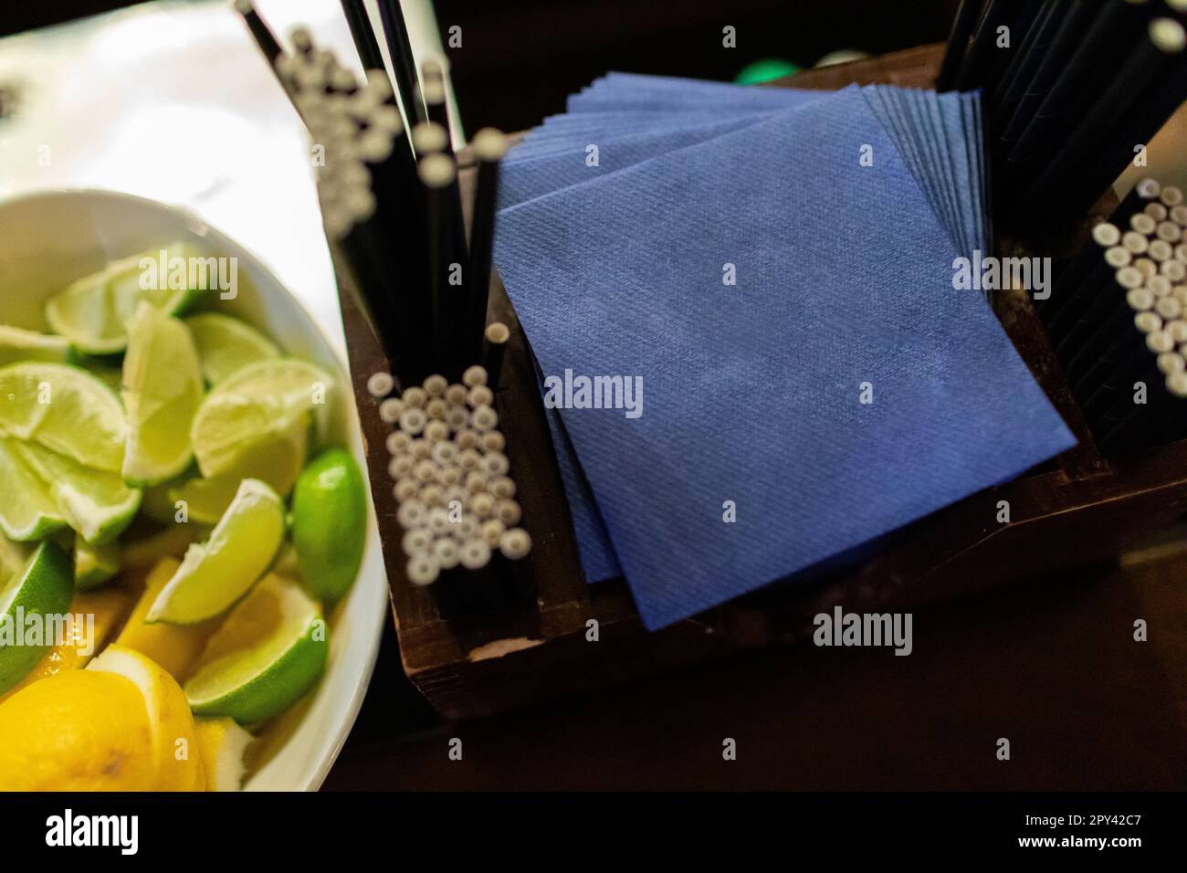 Blue cocktail napkins with fresh cut lime wedges at bartender station