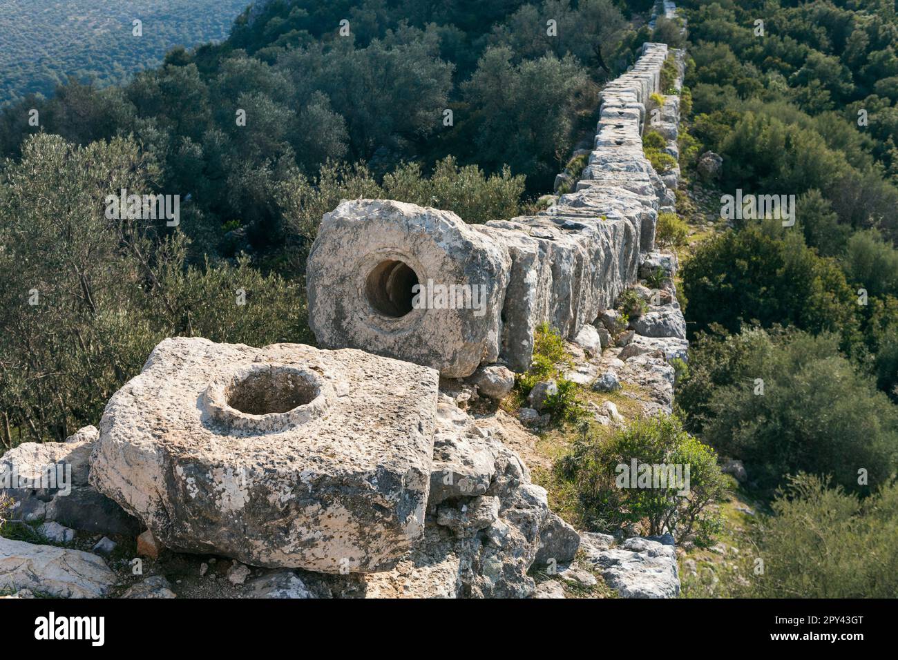 Ruins of old Roman Aqueduct. View Delikkemer Bridge at olive forest near Mediterranean sea coast