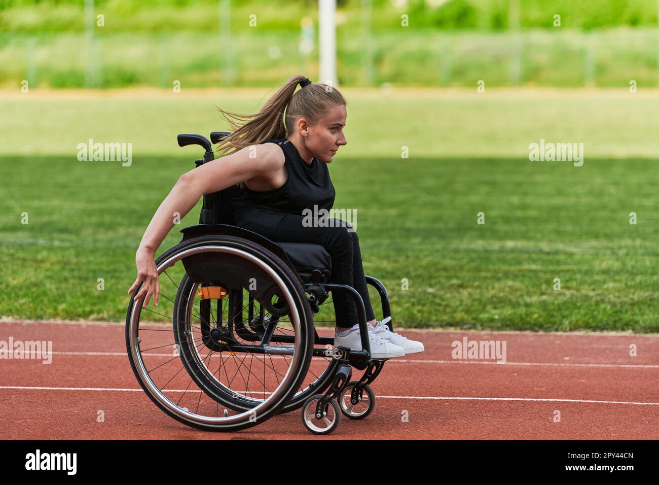 A woman with disablity driving a wheelchair on a track while preparing ...