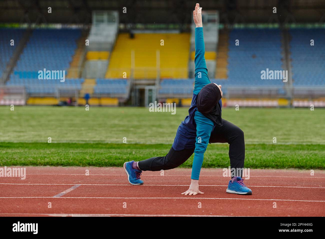 A Muslim woman in a burqa, an Islamic sports outfit, is doing body ...