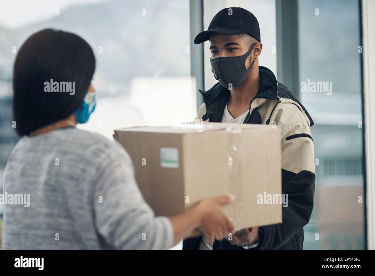 Safety is first order of the day. a masked young woman receiving a ...