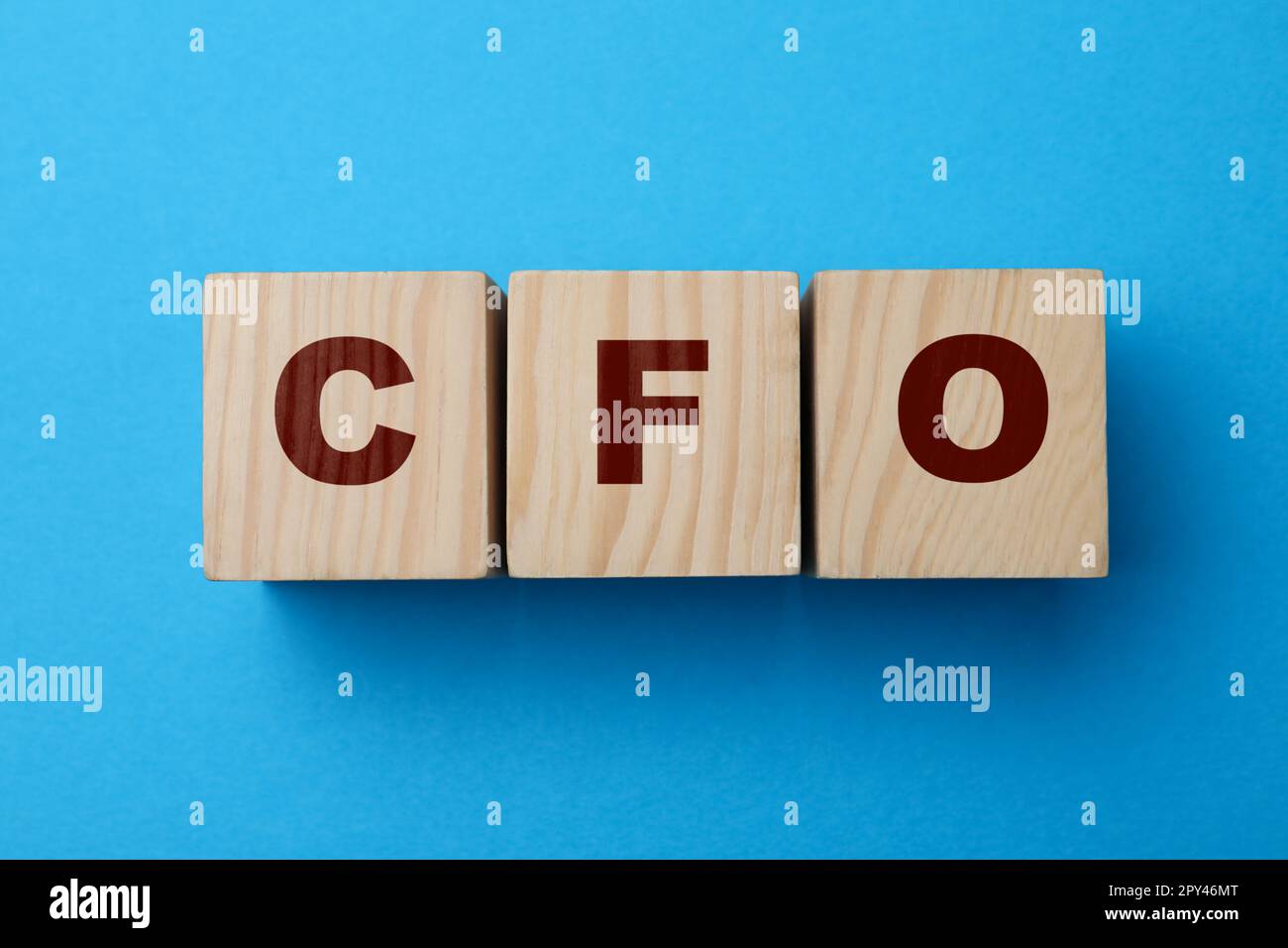 Abbreviation CFO of wooden cubes on blue background, flat lay. Financial management Stock Photo