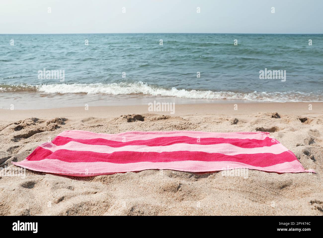 Pink striped towel on beach sand near sea Stock Photo - Alamy