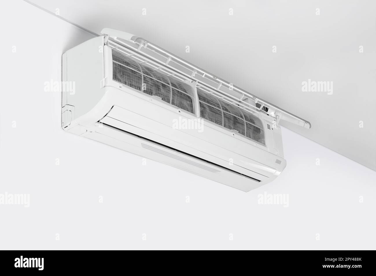 Modern air conditioner on white wall indoors Stock Photo - Alamy