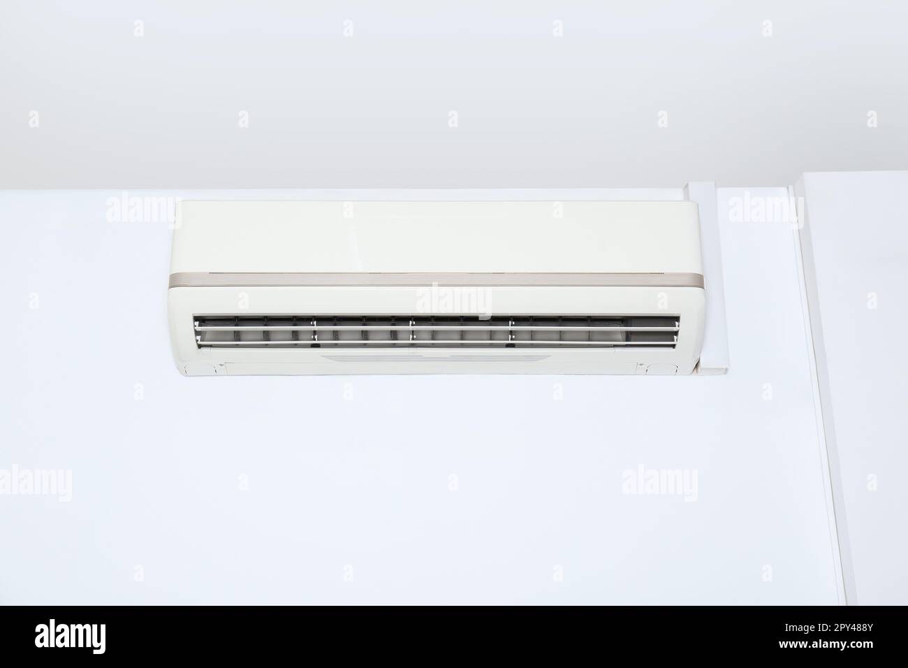 Modern air conditioner on white wall indoors Stock Photo - Alamy