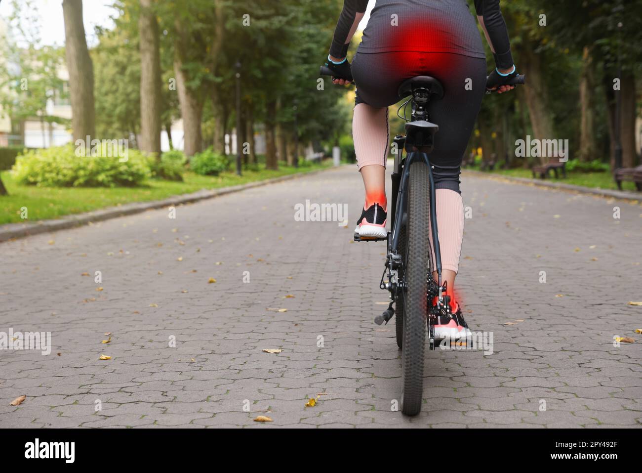 Problem of injured coccyx. Woman riding bicycle on road Stock Photo Alamy
