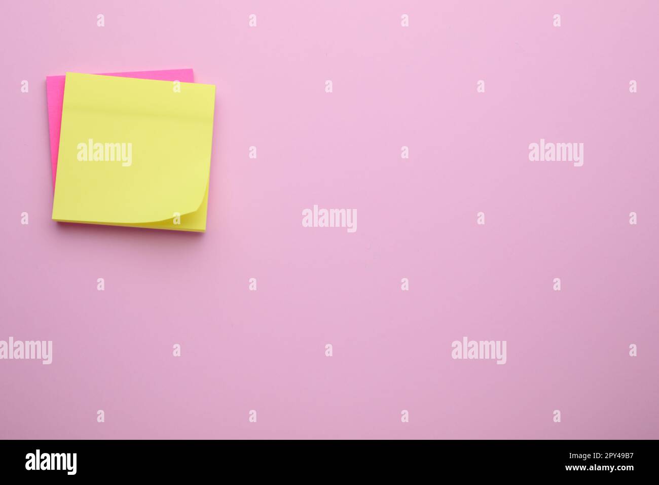 Paper notes on pale pink background, top view. Space for text Stock Photo