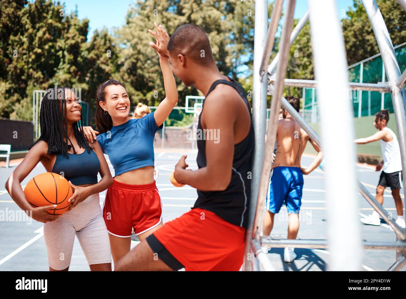 What an awesome game that was. a sporty young woman giving her teammate a high five on a basketball court. Stock Photo