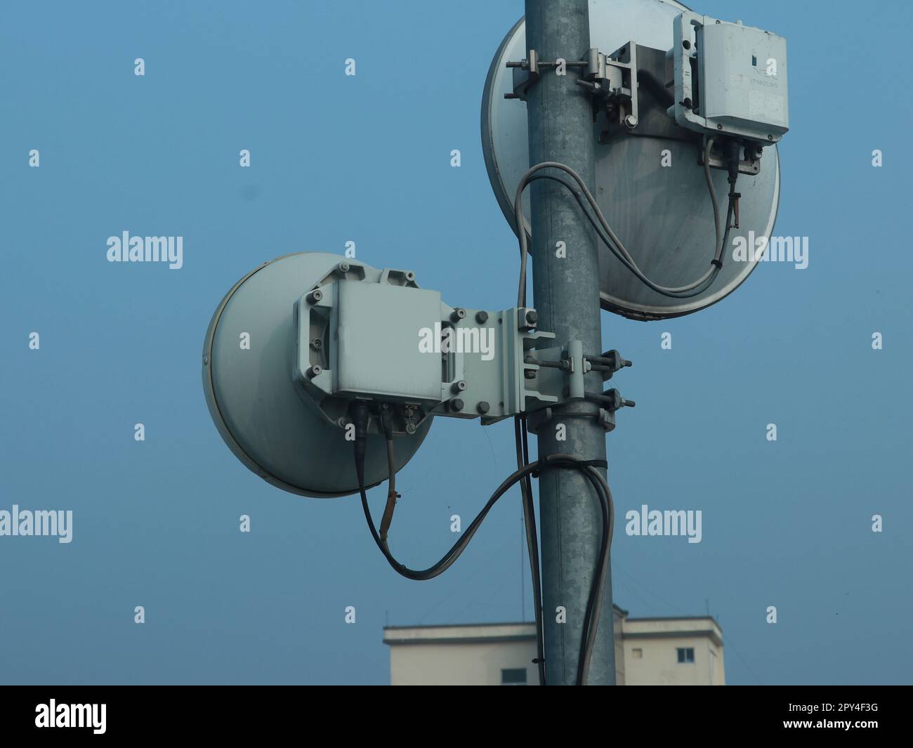 Microwave radio Link antenna mounted on a radio tower with blue sky in the background side view portrait Stock Photo