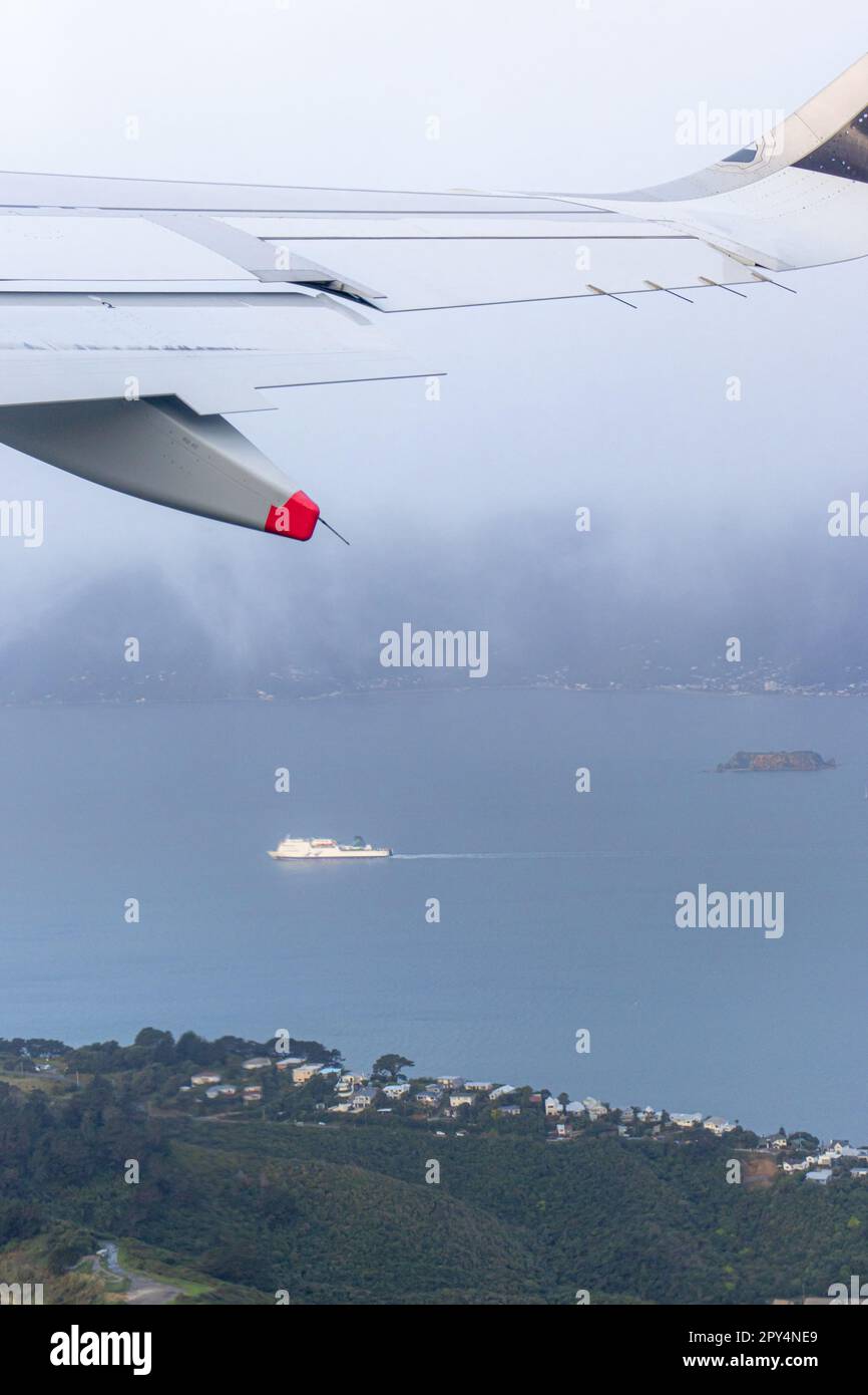 An aerial view of Wellington City and Harbour viewed from an aircraft window, including Somes Island and the Interislander Ferry. Stock Photo