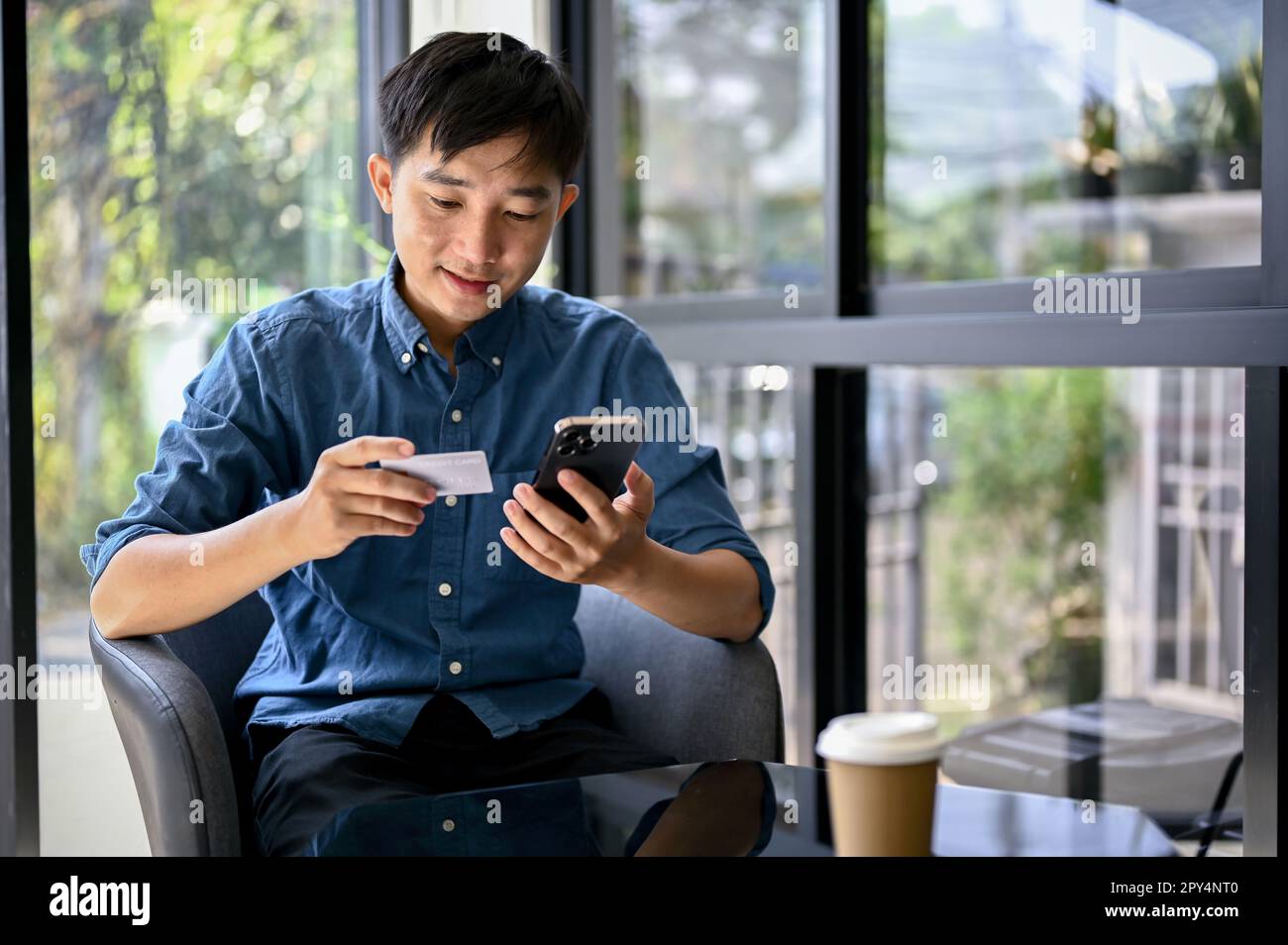 Happy and handsome millennial Asian man using mobile banking ...