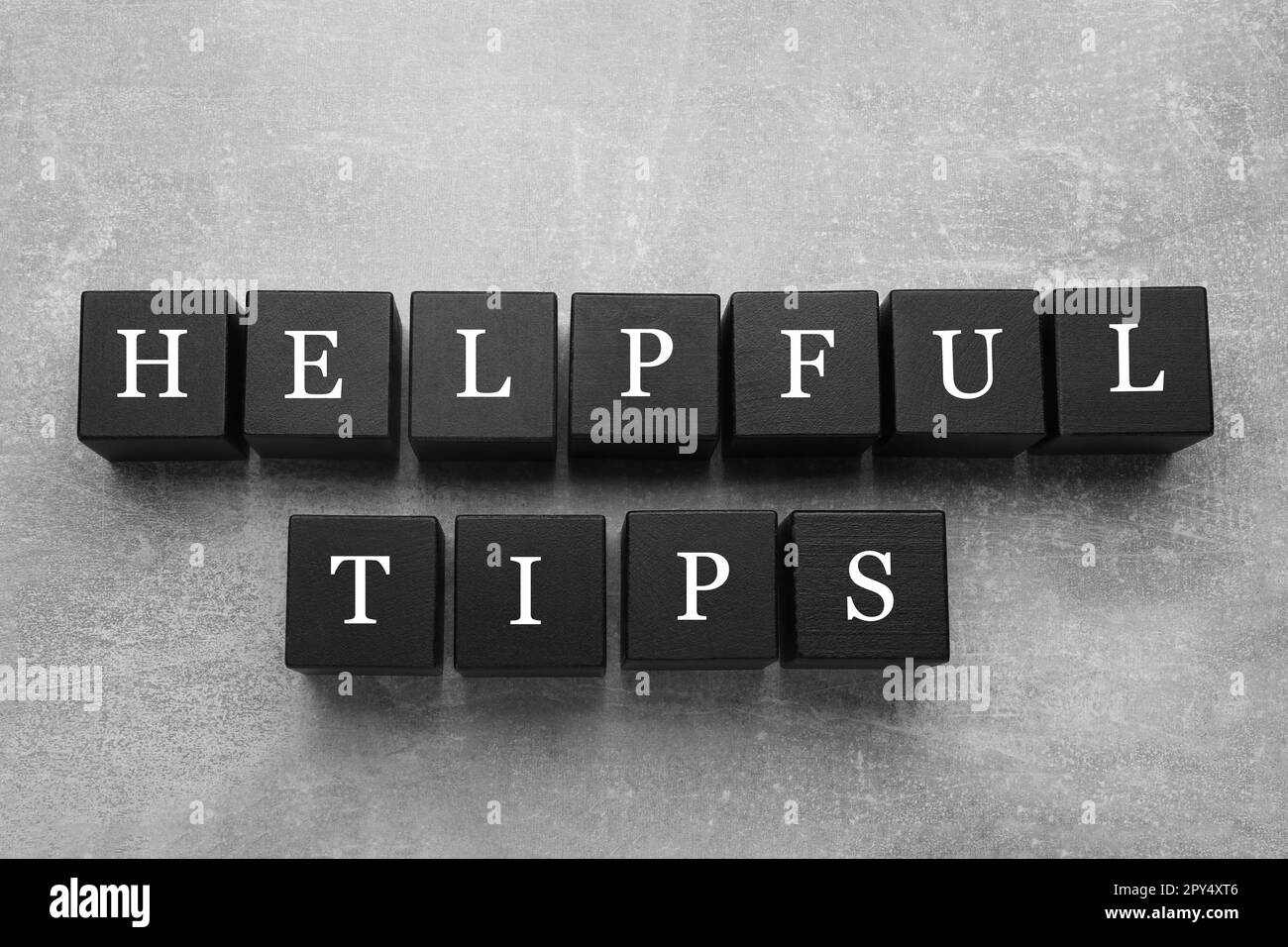Text Helpful Tips made of black cubes with letters on grey table, top view Stock Photo
