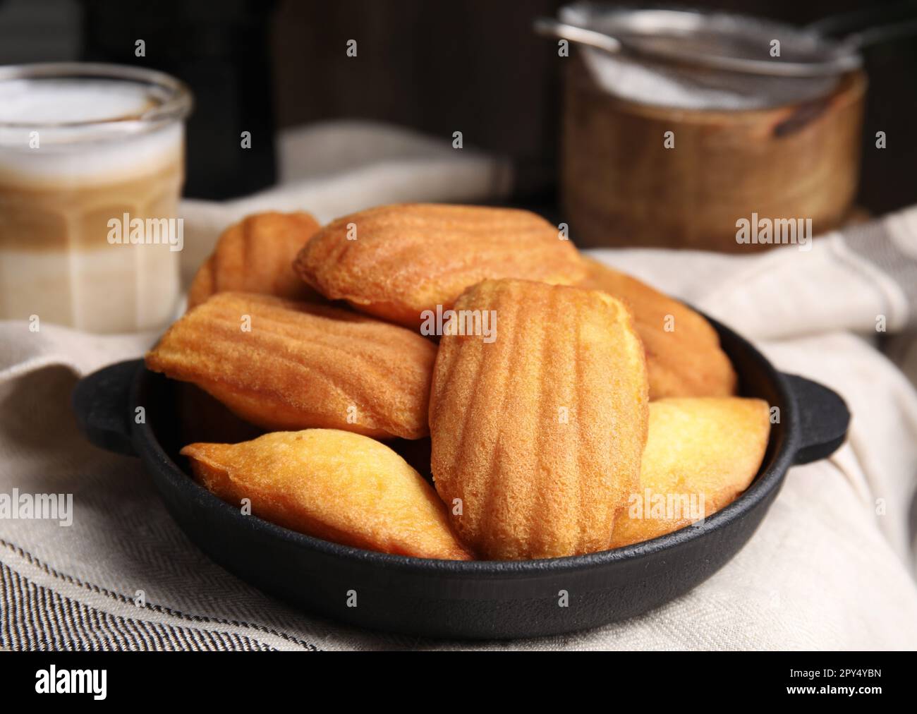 Delicious madeleine cakes in frying pan on table, closeup Stock Photo