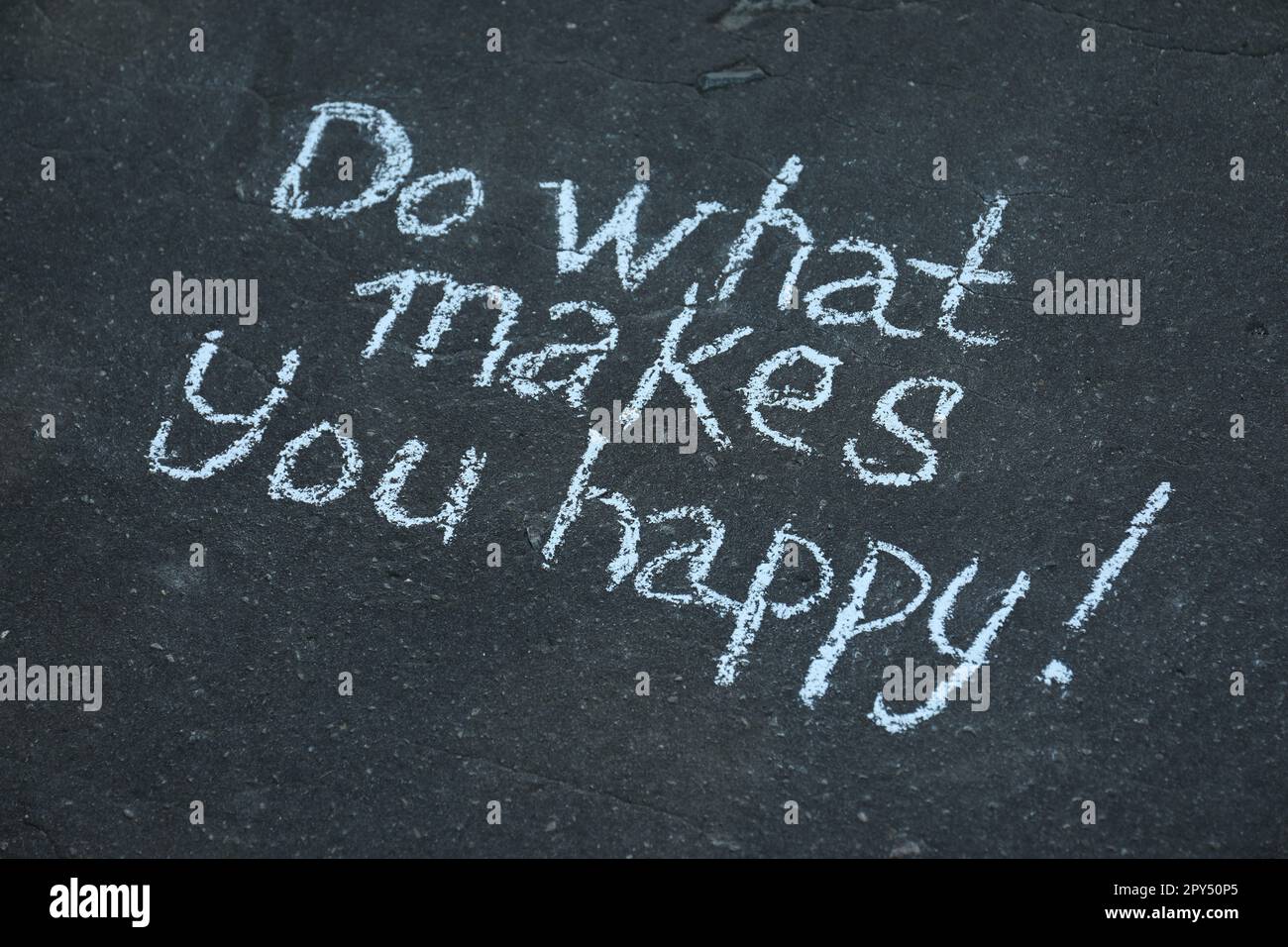 Phrase Do What Makes You Happy with exclamation mark written on asphalt Stock Photo