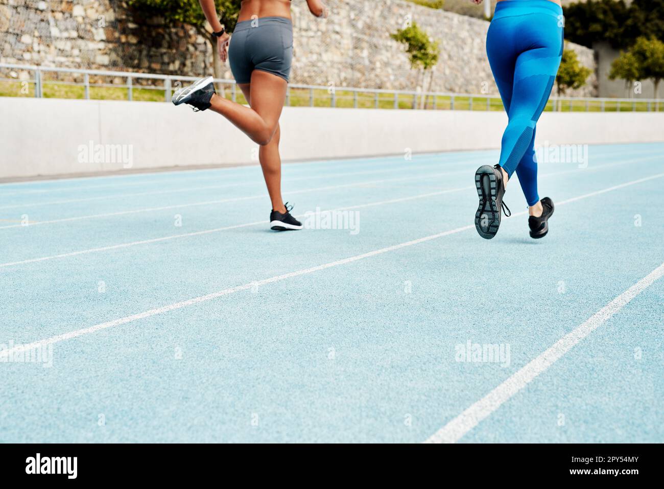 We Run At The Same Pace Two Unrecognizable Athletes Running Along A Track Field Alone During An We Run At The Same Pace Two Unrecognizable Athletes Running Along A Track Field Alone During An
