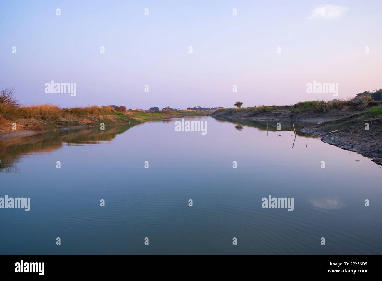 Arial View Canal with green grass and vegetation reflected in the water nearby Padma river in Bangladesh Stock Photo