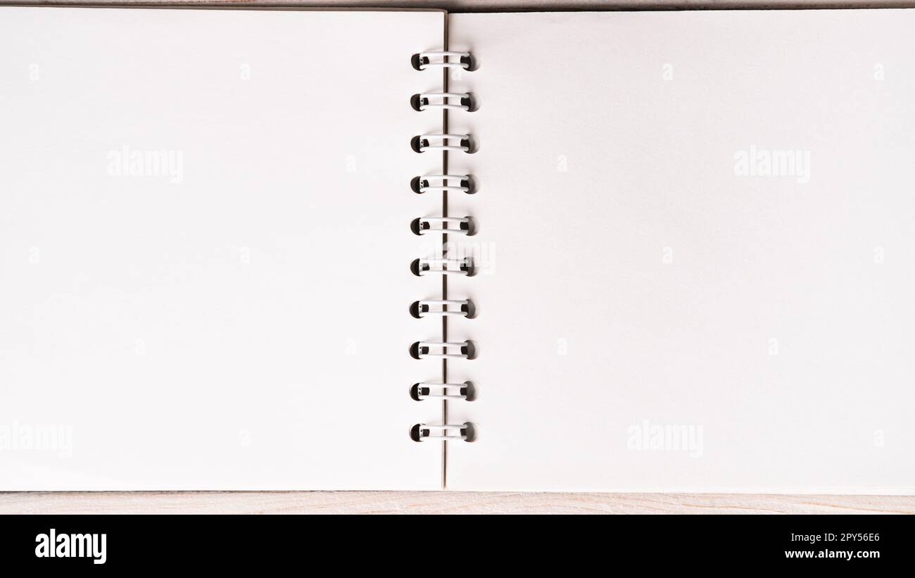 Flat lay of open blank empty spiral sketchbook notebook textbook with ring binder. Art, drawing, notes, information. Stock Photo