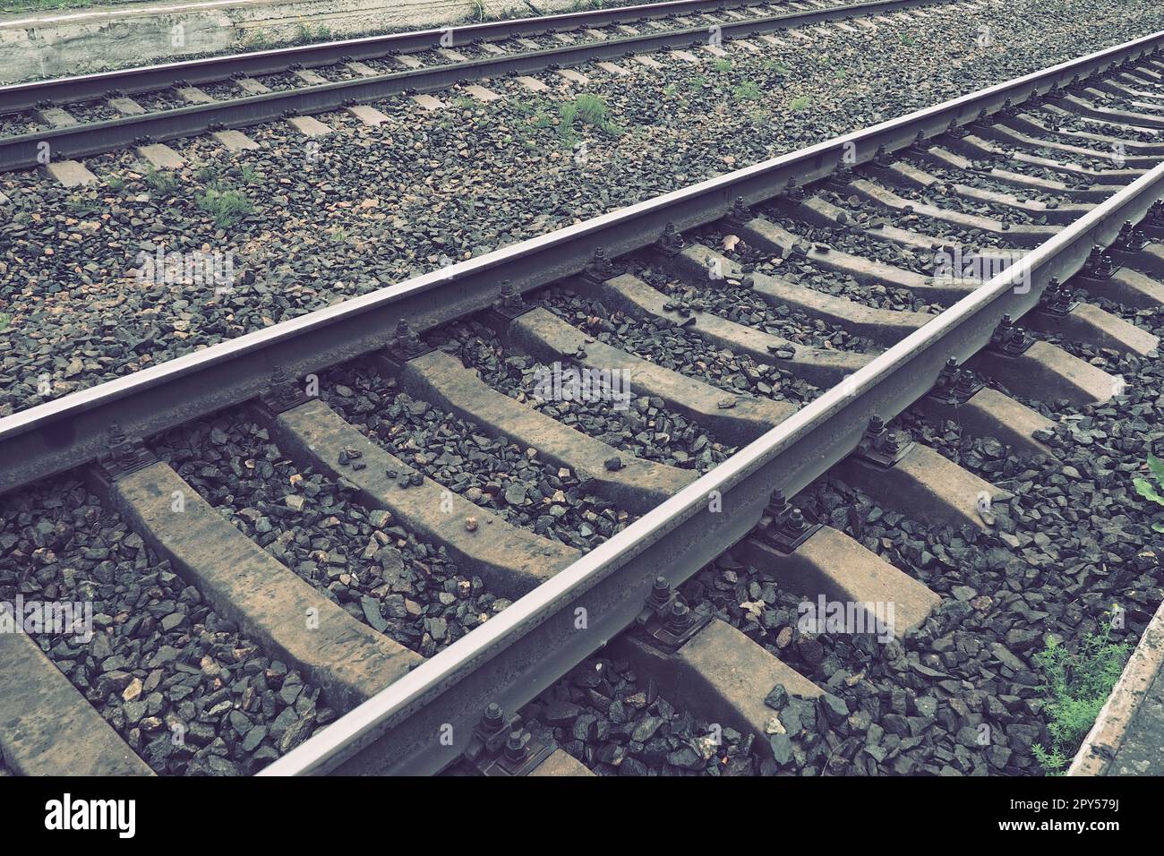 Railways. Metal steel rails and wooden sleepers. Rivets and fasteners on the railroad. Stony backfill of railway tracks. Station Nyrki, Karelia. Stock Photo