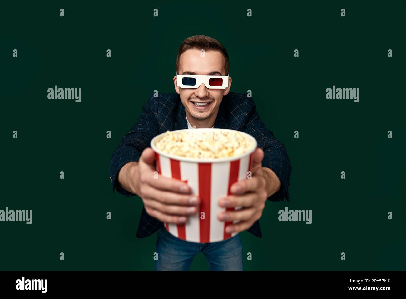 Young caucasian man in 3d glasses eating popcorn Stock Photo