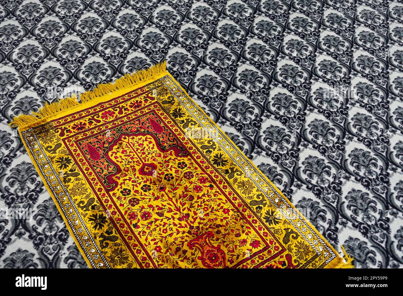 Prayer is performed on the prayer rug laid in the masjid, yellow prayer