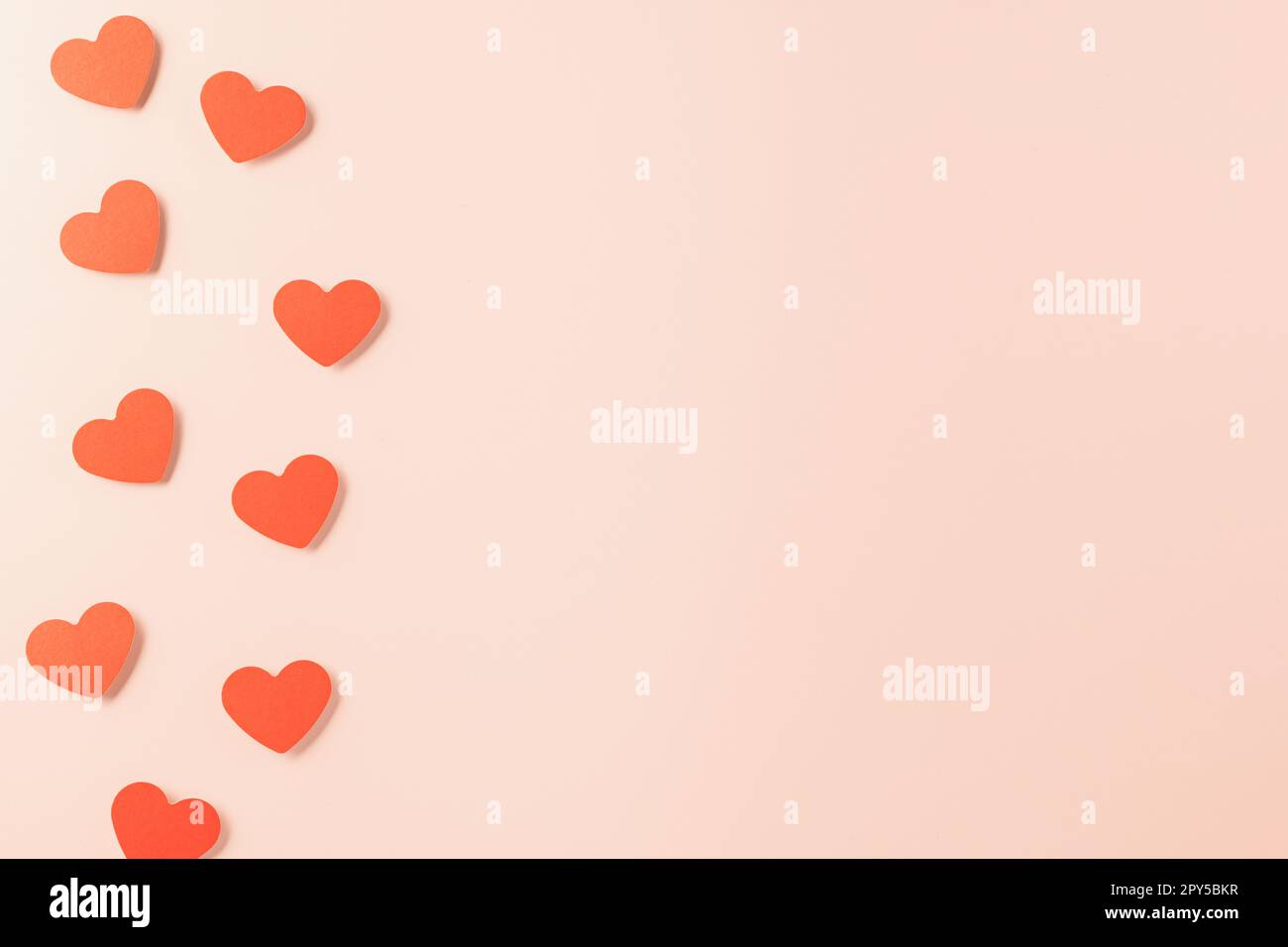 Beautiful red paper hearts shape cutting pastel pink background Stock Photo