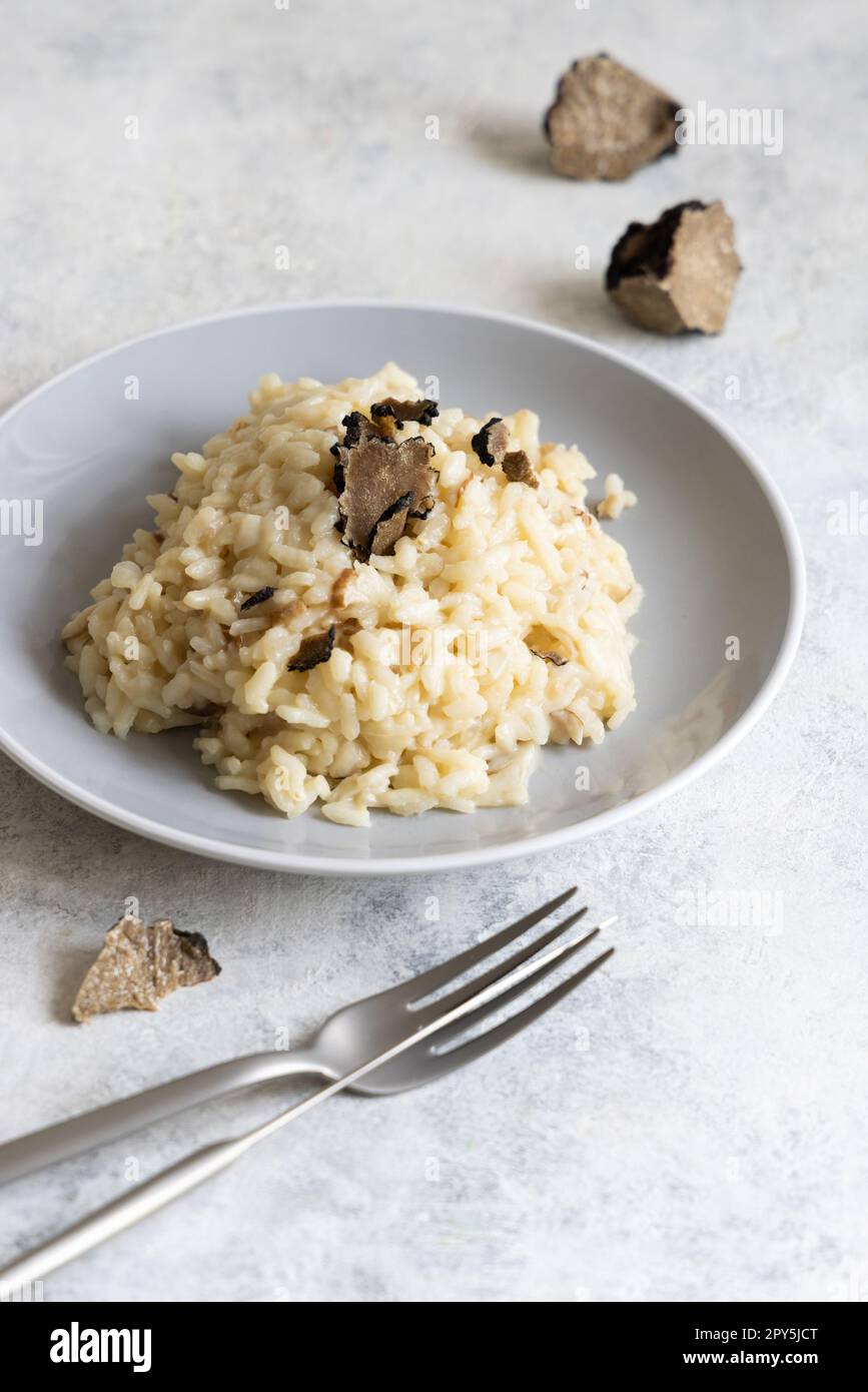 Risotto with porcini mushrooms and black truffles served in a plate top view, gourmet cousine Stock Photo